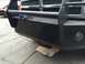 1997 Dodge 3500 - Close-up of a heavy-duty front bumper and brush guard, with a red vehicle in the background.