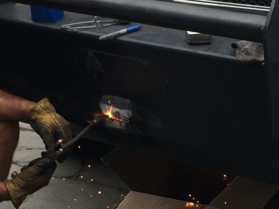 Welding a metal part onto a black bumper