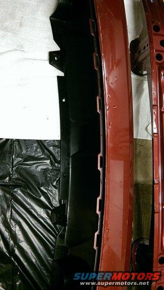 Red car bumper with black plastic trim and a Supermotors.net watermark