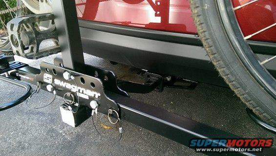 Red vehicle rear bumper with hitch and Swagman bike rack