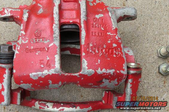 Red brake caliper with "VW" logo and "Germany" text, showing wear