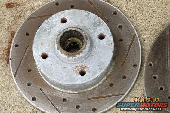Slotted brake rotor with visible rust and wear
