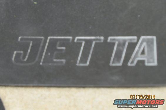 Embossed Jetta emblem on dark background