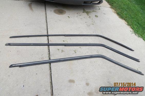 Three car window trim pieces laid out on concrete