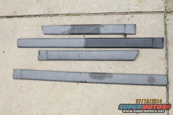 Four gray car door trim pieces laid out on concrete. One piece has a diagonal cut at the end