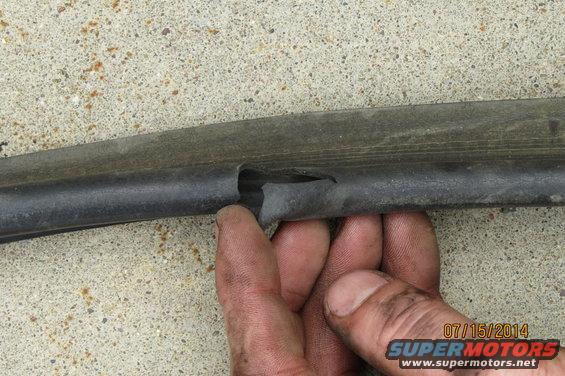 Torn rubber seal with a hand holding it