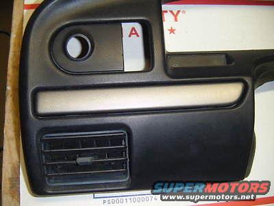 Black dashboard trim piece with air vent and circular cutout. Text 'SUPERMOTORS' visible