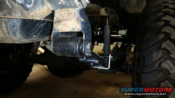 Close-up of a vehicle's rear leaf spring suspension and large tire