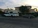 1997 Dodge 3500 - A white pickup truck tows a boat trailer on a street with houses in the background.