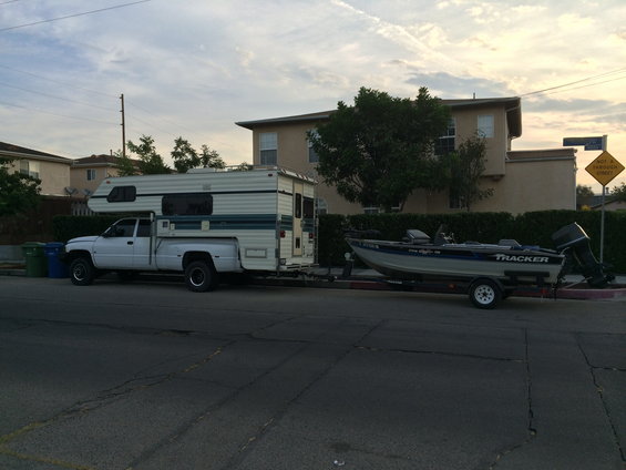 White 1997 Dodge 3500 pickup truck with camper and boat trailer