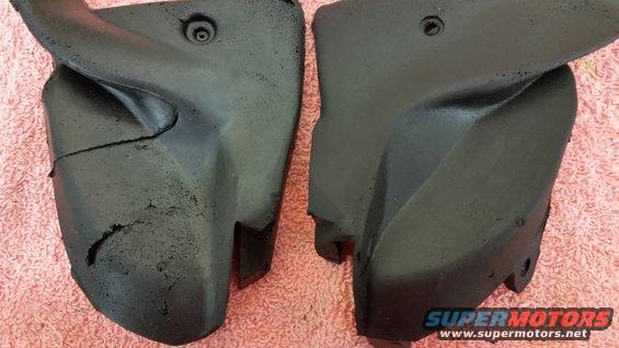 Two black plastic automotive parts, one cracked, on a pink textured surface