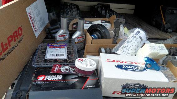 Boxes of automotive parts including Ford Racing components and Sealed Power engine systems
