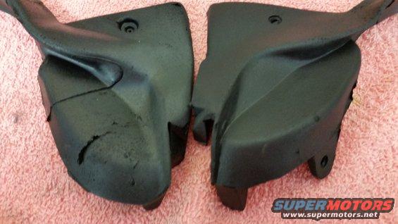 Two black plastic automotive parts on a pink surface