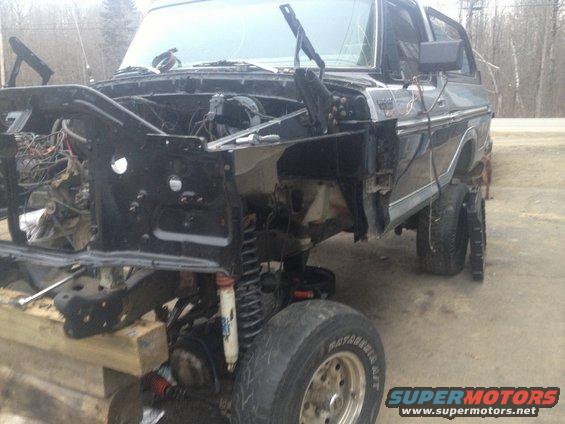 Black Ford Bronco with front end removed, showing engine components and suspension