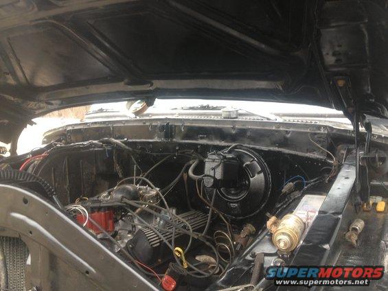 Engine bay with V8 engine, brake booster, and master cylinder visible. Hood is open