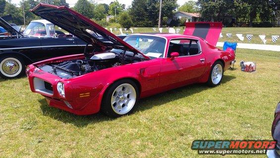 Red 1972 Pontiac Trans Am with hood and trunk open, showing engine and rear spoiler