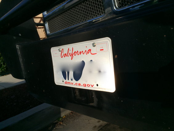 Front bumper of a vehicle with a California license plate. The plate number is obscured