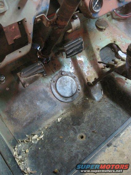 Floor pan and pedals inside an old vehicle. Looks like it needs work