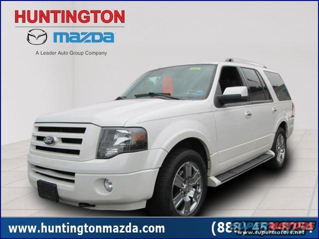 White Ford Expedition SUV parked, front passenger side visible. Dealership logos at top