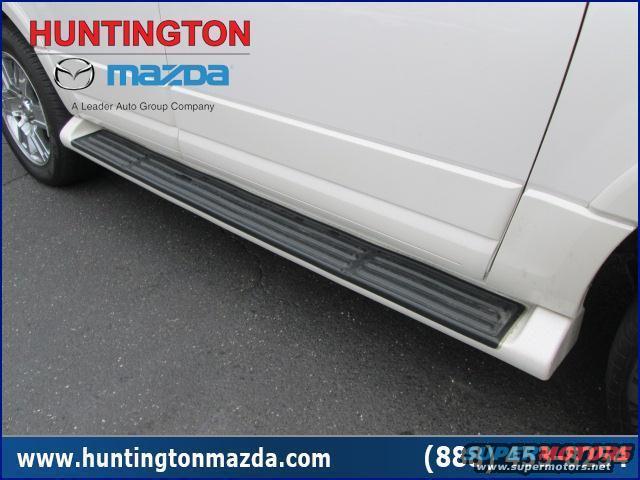 White SUV side view with running boards. Huntington Mazda logo visible
