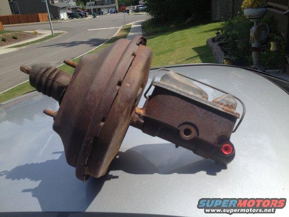 Rusty brake booster and master cylinder assembly on a car's hood