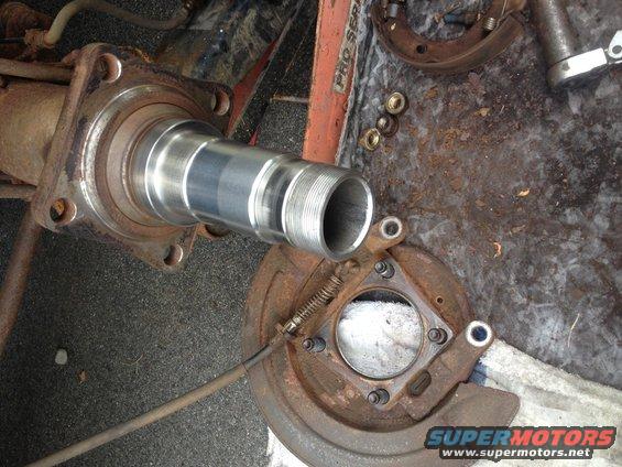 Close-up of a disassembled rear axle hub and spindle assembly with brake components