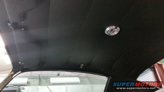 Car interior ceiling with dome light and sun visors. Supermotors.net logo visible