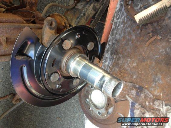 close-up of a vehicle's front wheel hub and brake rotor assembly, appears to be undergoing maintenance