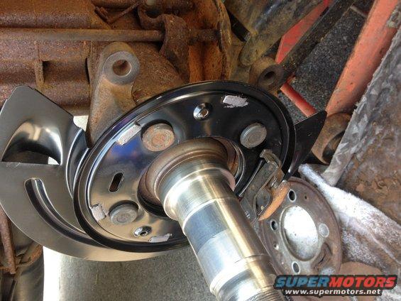 Vehicle rear axle assembly with new brake rotor and dust shield installed