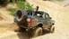 2014 Ford Bronco - Modified SUV navigates a challenging off-road trail with steep inclines and loose dirt.