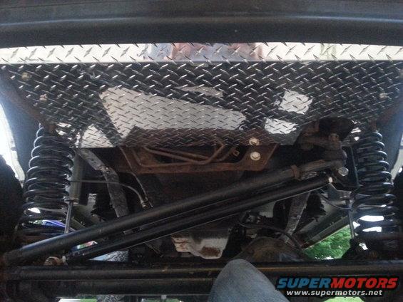 Diamond plate skid plate above suspension and steering components