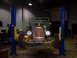 2004 Ford Crown Victoria - A vintage green hot rod is positioned on a car lift in a garage, ready for service.