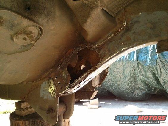 Heavily rusted frame section of a vehicle, possibly a Ford Bronco, showing significant corrosion and damage