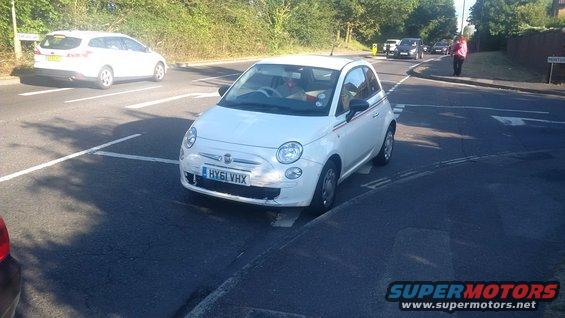 White Fiat 500 with license plate HY61 VHX stopped at a crosswalk. Another white car is visible in the background