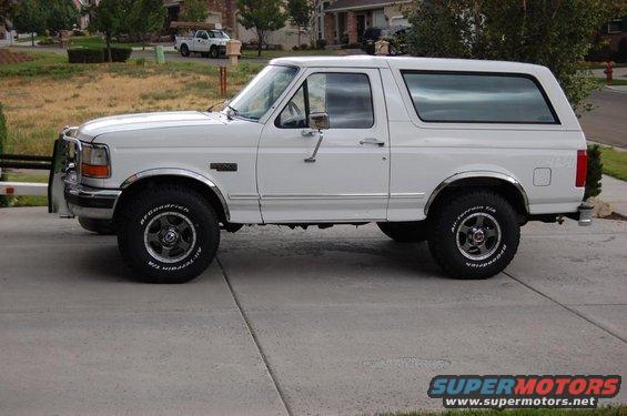 White Ford Bronco with chrome trim and bull bar, parked on a driveway