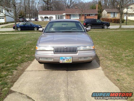 1994 Mercury Grand Marquis parked on driveway, blue sedan and black SUV in background
