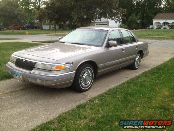 Tan 1994 Mercury Grand Marquis sedan parked on a driveway, front 3/4 view