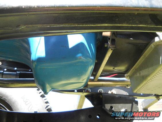 Underside of a vehicle showing the blue oil pan and chassis components