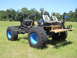 1992 Ford Bronco - This custom-built vehicle features a bare chassis, two bucket seats, and oversized tires with blue rims.