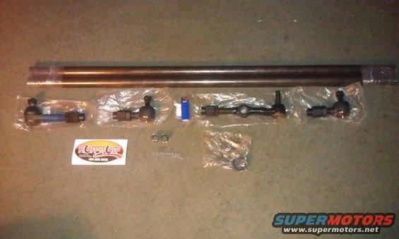 Steering linkage parts laid out on a floor, including tie rods and ball joints, with a 'RUFF STUFF' sticker