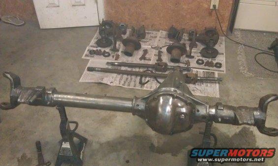 Vehicle differential and axle parts laid out on the floor and on newspapers