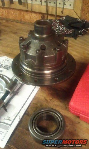Differential carrier and bearing on a wooden workbench with tools and a red case