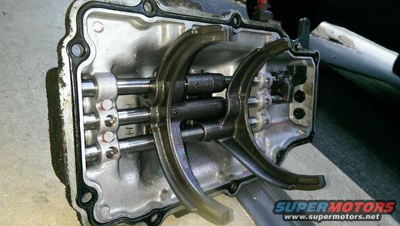 Transmission internal components with shift forks and rods, metal casing with gasket