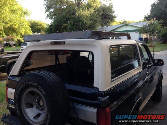 Rear view of a 1993 Ford Bronco with a custom roof rack and spare tire mounted on the back