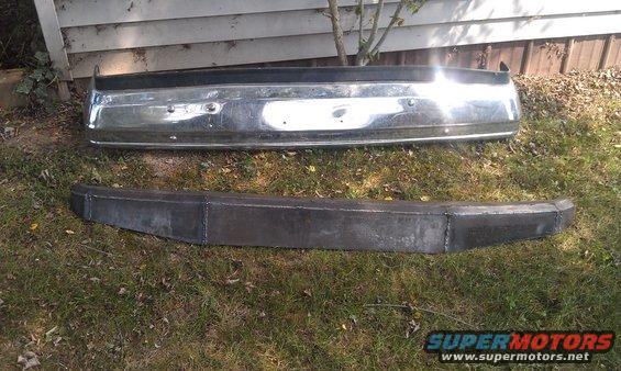 Chrome bumper above a welded steel bumper on grass