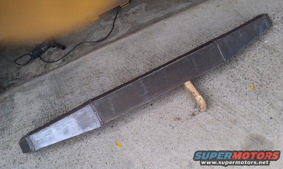 Fabricated steel bumper on concrete floor with grinder nearby