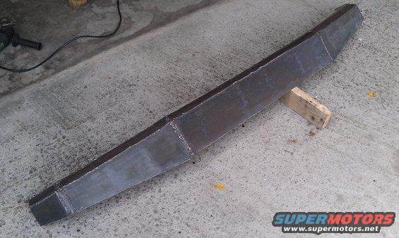 Custom fabricated steel bumper on concrete floor, supported by wood blocks