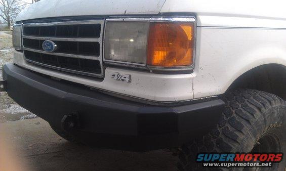 White Ford truck front end with black bumper and 4x4 badge