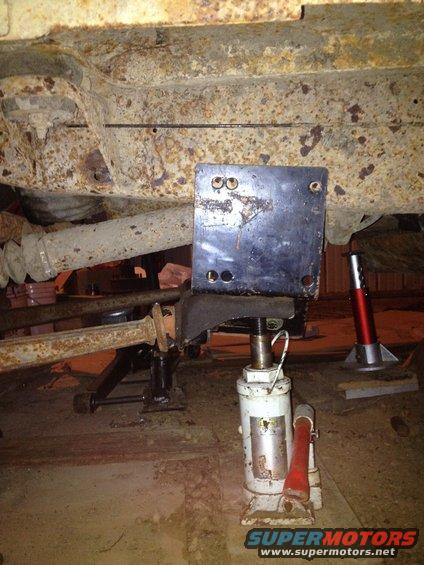 Undercarriage of a vehicle supported by jack stands and a hydraulic jack