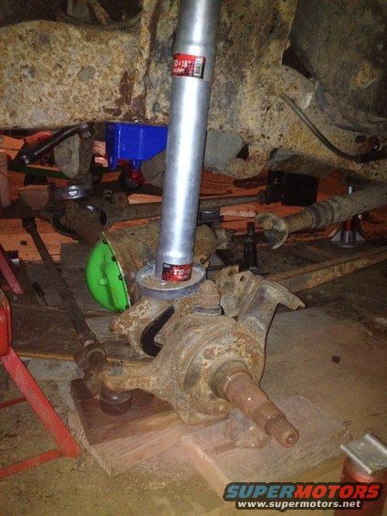 Rusty suspension parts with a silver pipe and green cap